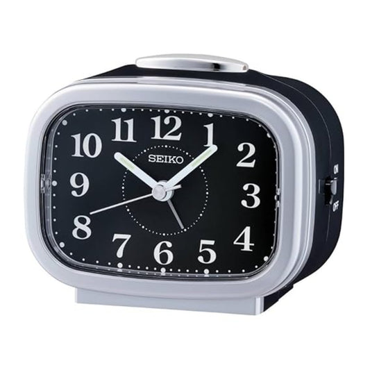 Seiko alarm clock with black face and silver casing on a white background