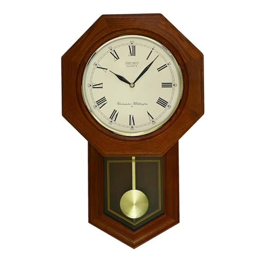 Wooden wall clock with pendulum on a white background