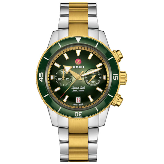 Two-tone silver and gold watch with green bezel on a white background