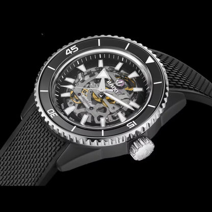 Black wristwatch with a detailed mechanical face on a black background