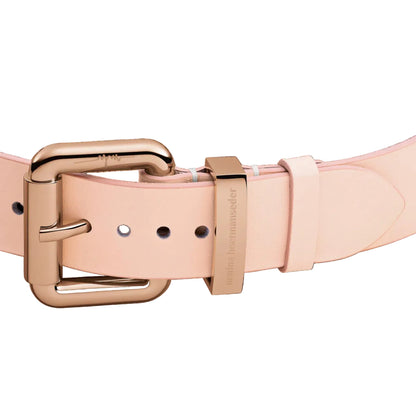 Rose gold belt buckle on a pink belt against a black background