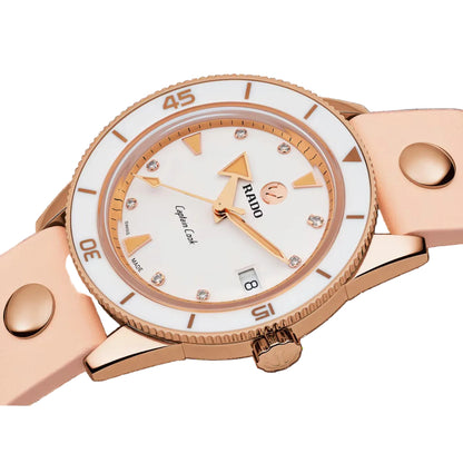 Rose gold watch with white dial on a black background