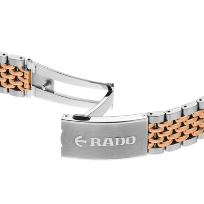 Close-up of a Rado watch band with rose gold and silver design on a white background