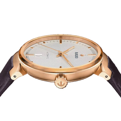 Rose gold watch with a dark strap on a black background