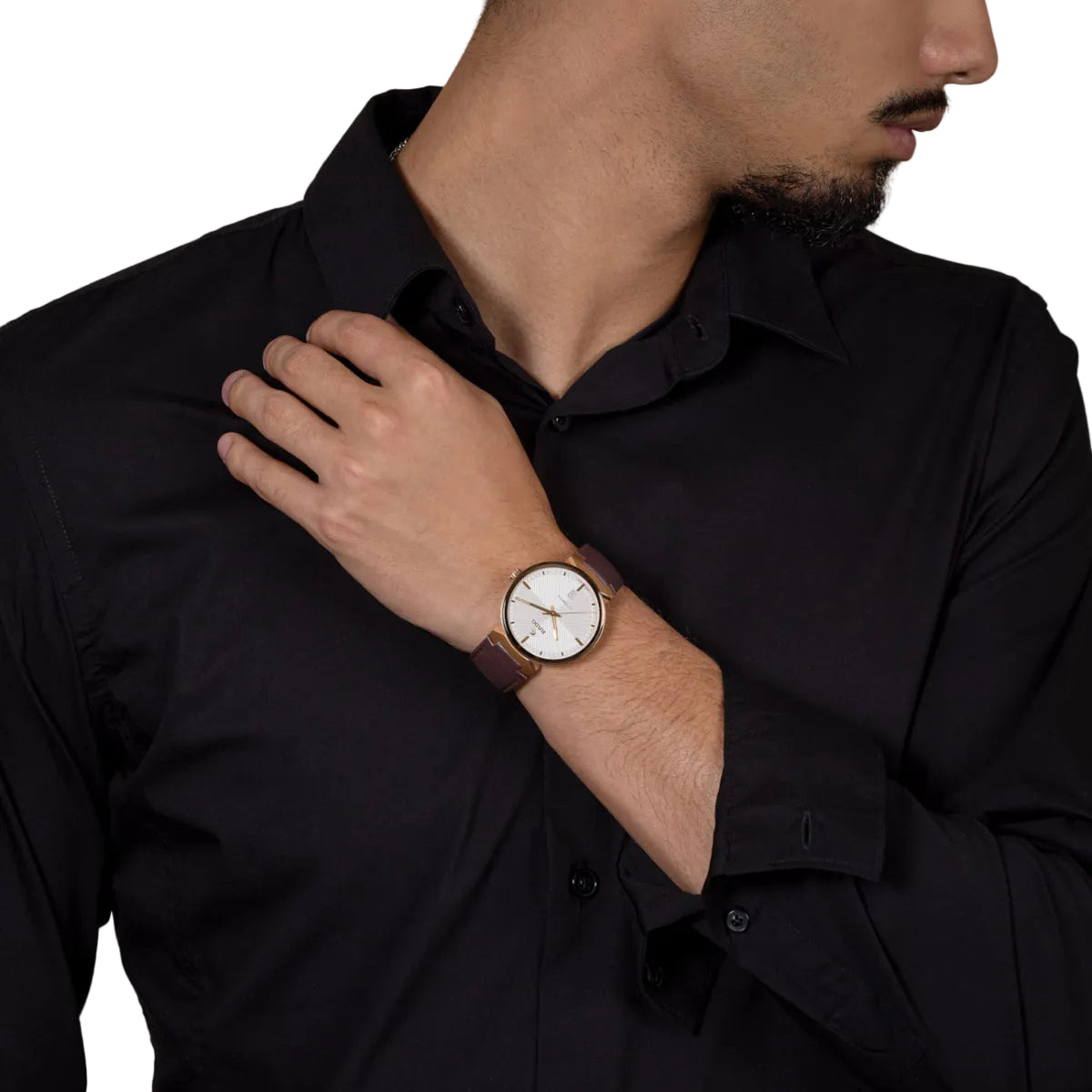 Man wearing a black shirt with a watch on his wrist against a beige background