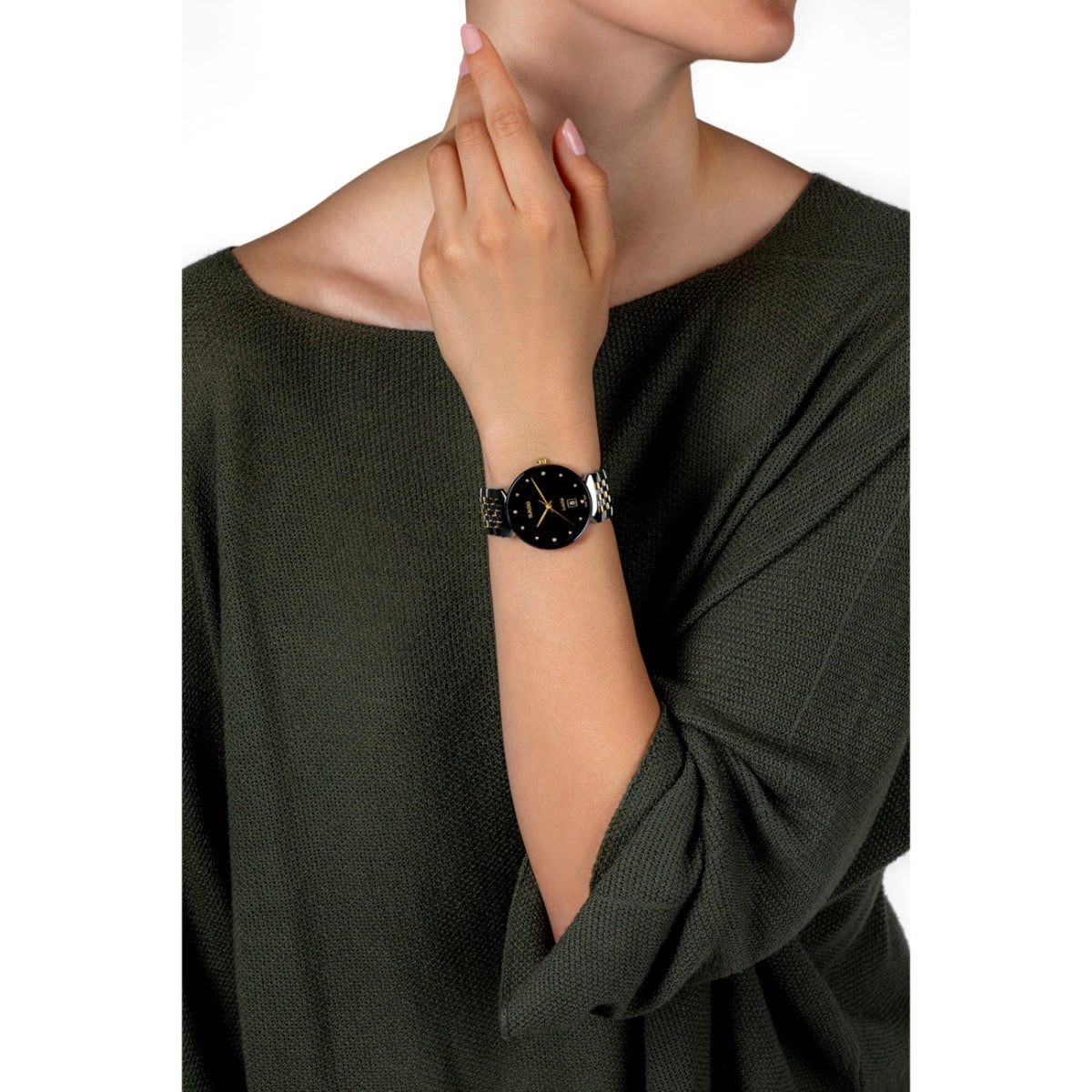 Woman wearing a black dress with a close-up of her wrist showing a watch.