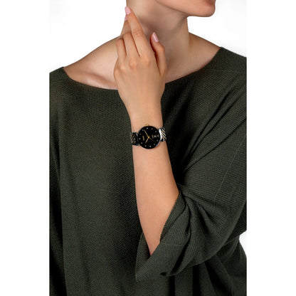 Woman wearing a black dress with a close-up of her wrist showing a watch.