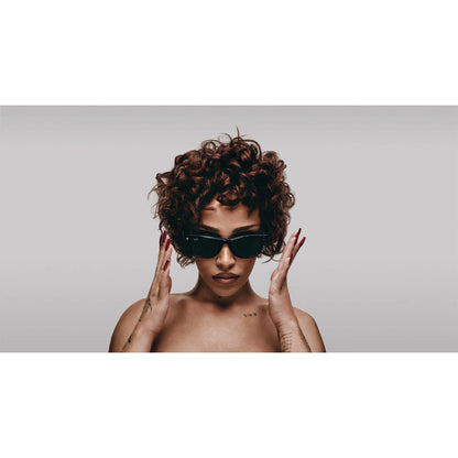 Woman wearing sunglasses with a neutral background