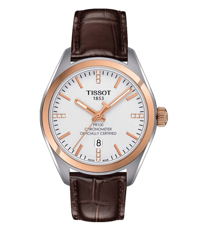 A Tissot PR 100 Lady COSC analog watch with a brown leather strap and silver dial, featuring three hands, a crown for time adjustment, and a buckle clasp.