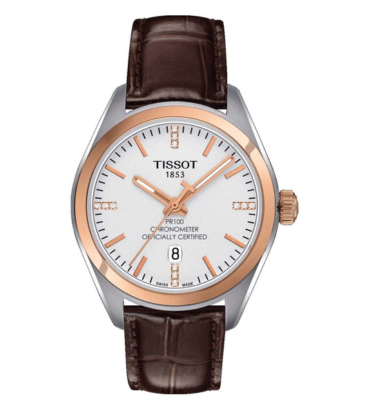 A Tissot PR 100 Lady COSC analog watch with a brown leather strap and silver dial, featuring three hands, a crown for time adjustment, and a buckle clasp.