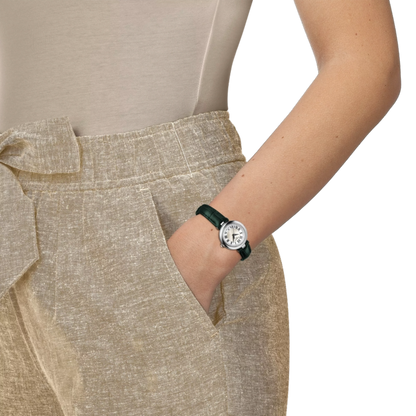 Person wearing a beige outfit with a watch on a white background