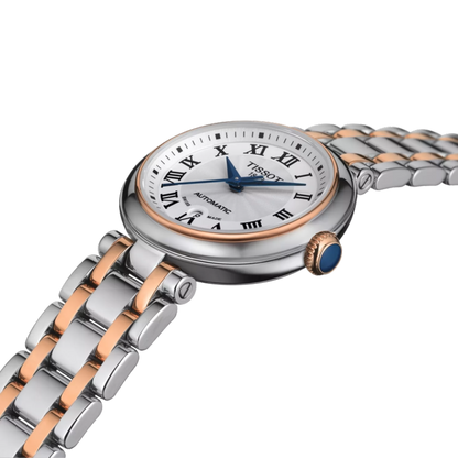 Tissot watch with silver and rose gold band on a white background