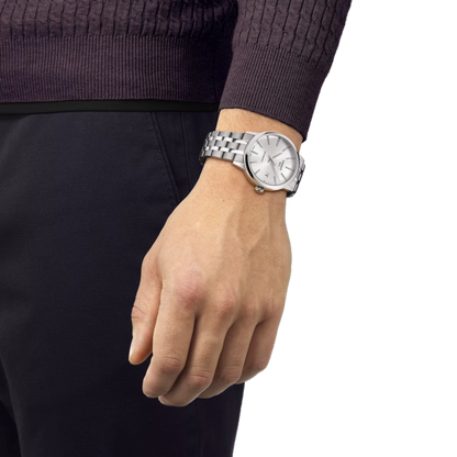 Hand wearing a silver watch on a white background