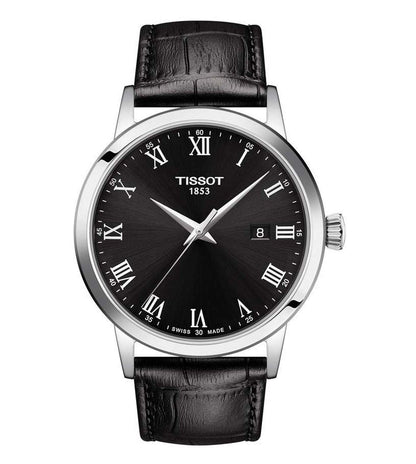 A TISSOT CLASSIC DREAM men's analog watch with a black dial, silver case, and black leather strap.