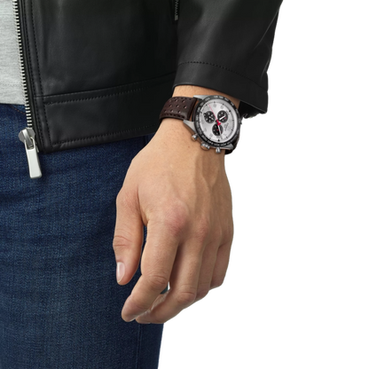 Hand wearing a watch with a black leather strap on a white background