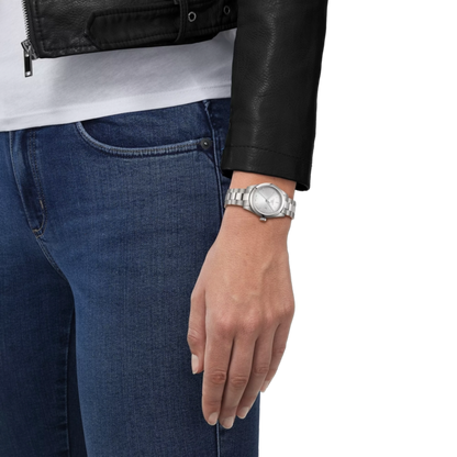 Person wearing a silver watch on a white background