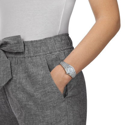 Person wearing gray pants with a watch on a white background