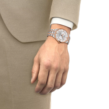 Two Tissot watches, one with a beige strap and rose gold case, the other with a green strap and silver case, on a white background.