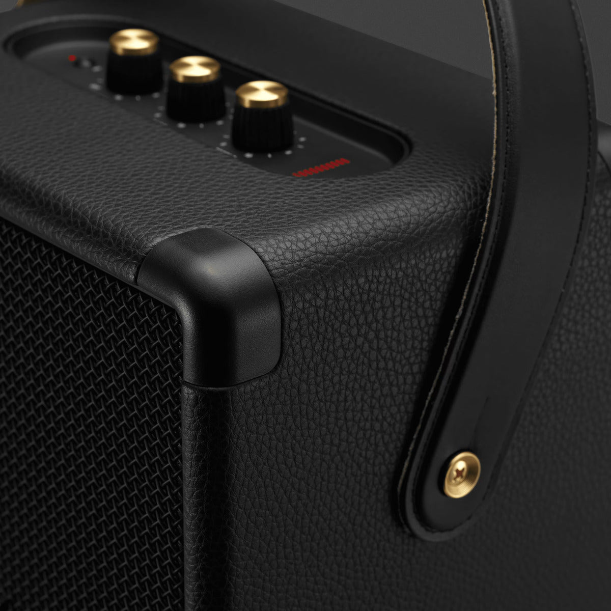 Black portable speaker with control knobs and brand name on a dark background