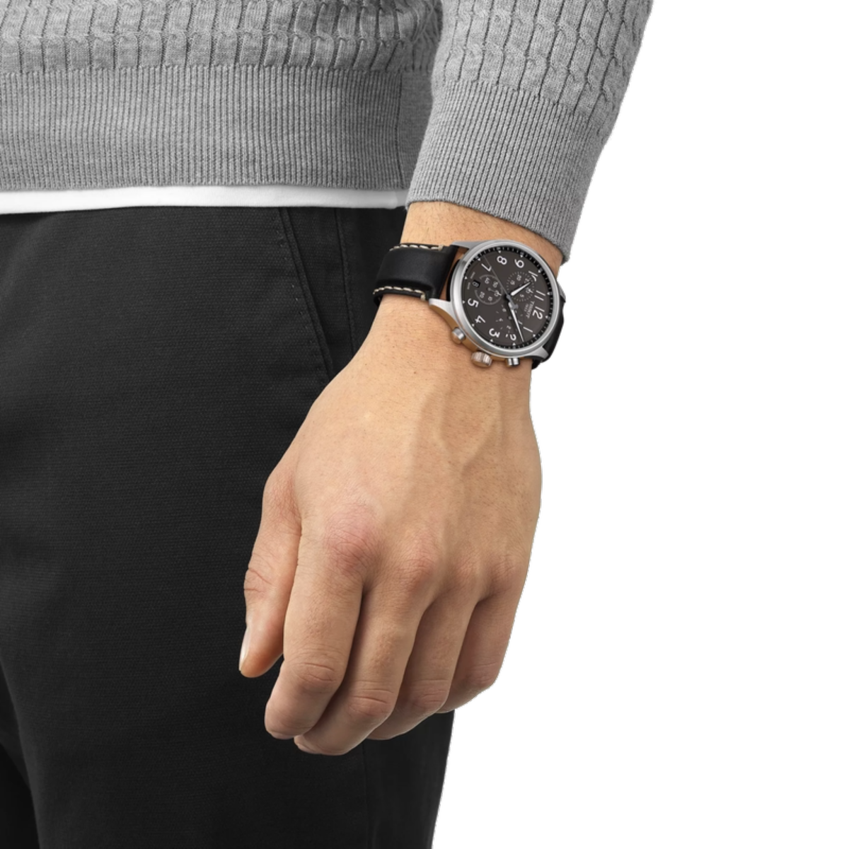 Hand wearing a black watch with a gray sweater and black pants on a white background