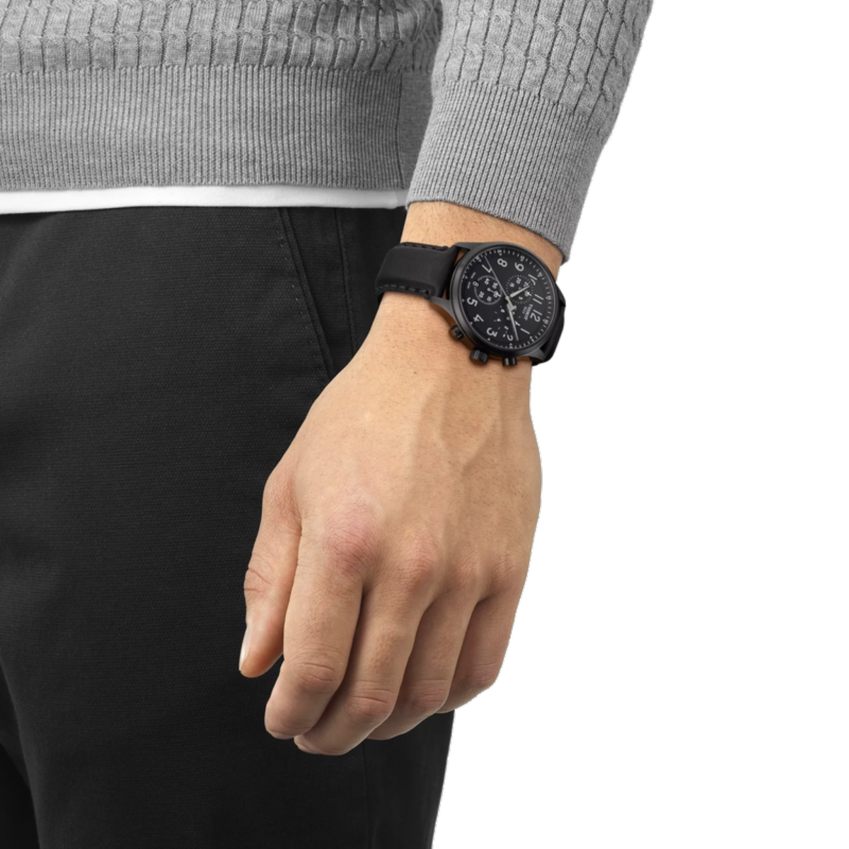 Person wearing a black wristwatch on a plain background