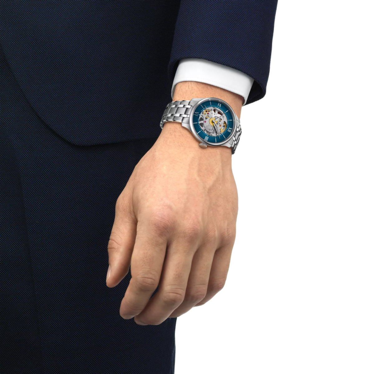 Hand wearing a silver watch with a blue face on a white background