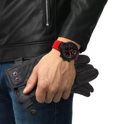 Person wearing a black leather jacket and blue jeans, holding a black wallet, with a focus on a red wristwatch.