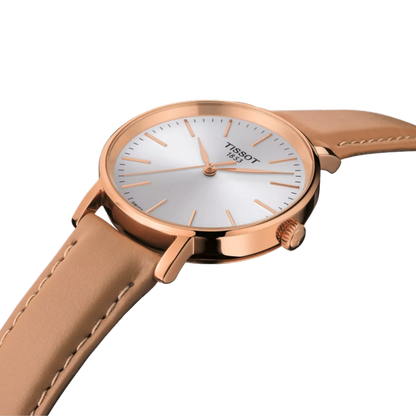 Rose gold Tissot watch with beige leather strap on a white background