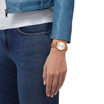 Person wearing a gold watch with a white face on a plain background