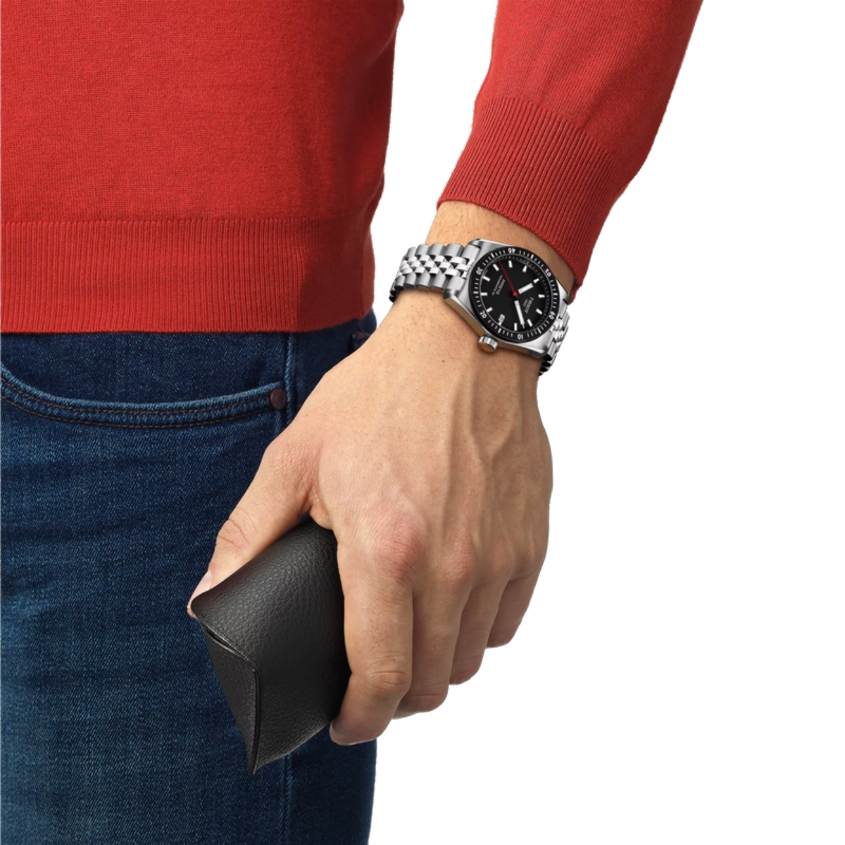 Hand wearing a watch holding a black wallet, with red sweater and blue jeans on a white background