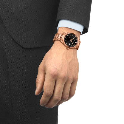 Rose gold watch on a person's wrist with a black strap against a white background