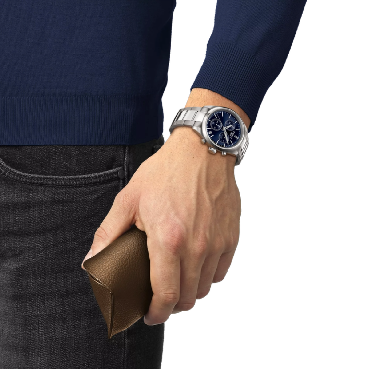 Hand wearing a silver watch with a blue face, holding a brown leather wallet, against a white background.