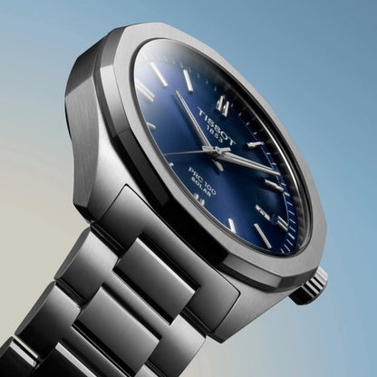 Silver Tissot watch with blue dial on a gradient background