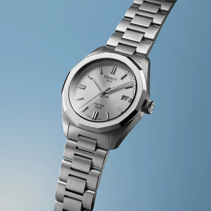 Silver Tissot watch on a light blue background