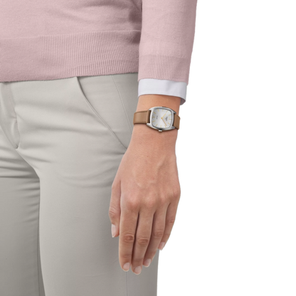 Hand wearing a watch with a pink sweater and light gray pants on a white background
