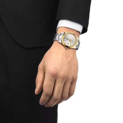 Hand wearing a silver and gold watch on a white background
