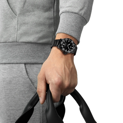 Person wearing a black watch on a gray background