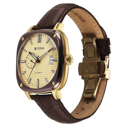 Titan watch with brown leather strap and gold case on white background