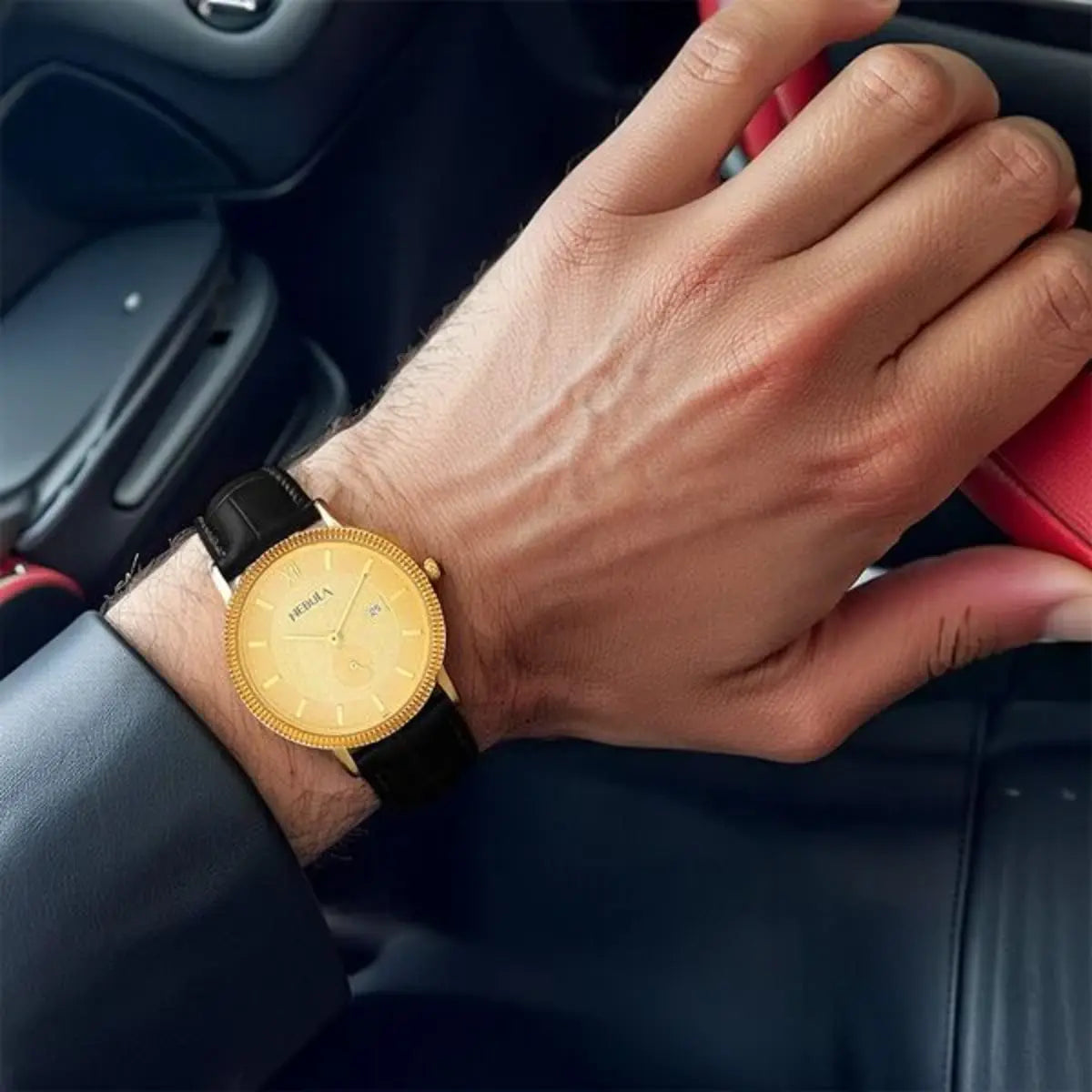 Hand wearing a gold watch with a black strap inside a car.