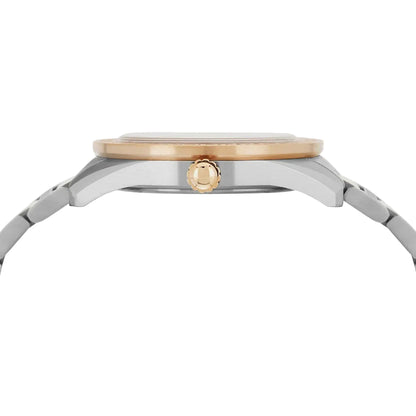 Close-up of a watch with a gold and silver band on a light gray background