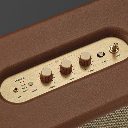 Close-up of a brown and gold audio control panel with knobs and buttons.