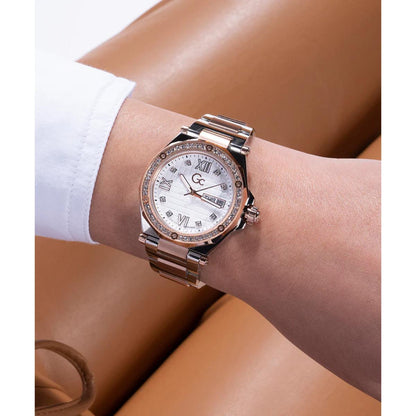 Rose gold watch with diamond accents on a wrist against a neutral background