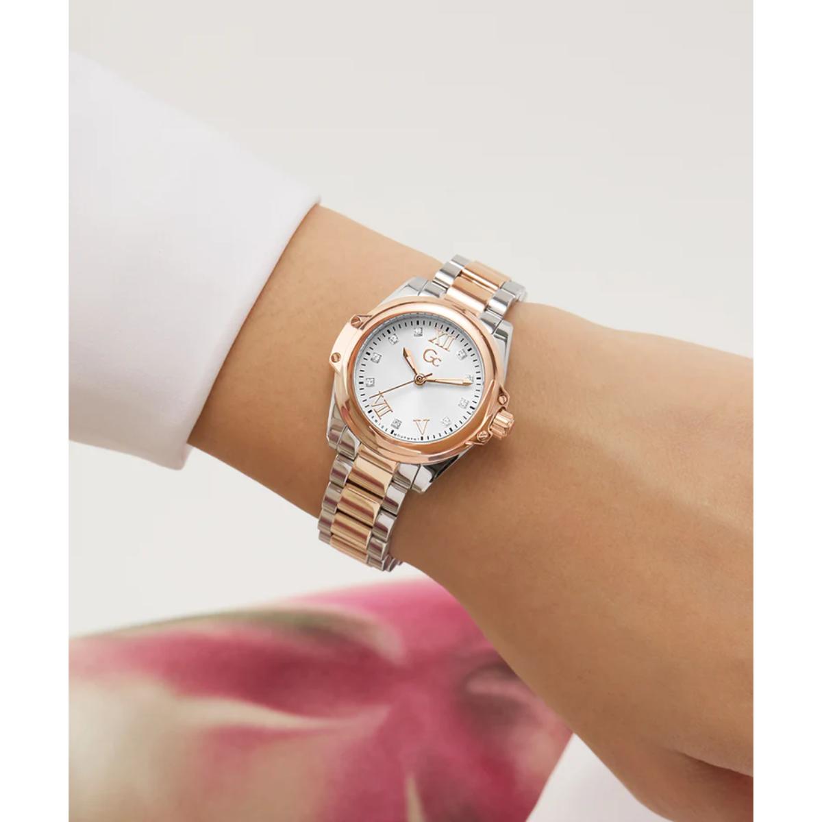 Rose gold watch on a wrist with a blurred floral background