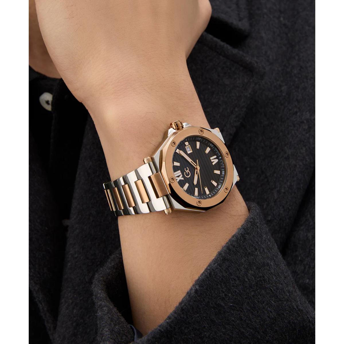 Gold and silver watch on a wrist with a dark background