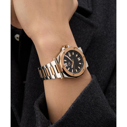 Gold and silver watch on a wrist with a dark background