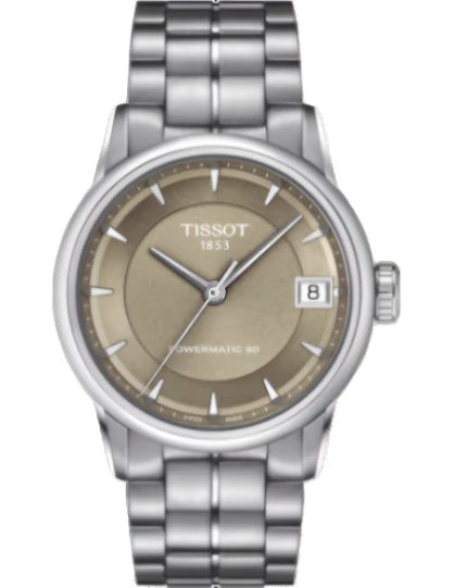 A TISSOT women's analog watch with a brown dial, stainless steel case, and a grey stainless steel bracelet.